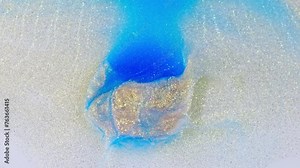 Blue and purple ink merging in water, creating an abstract cloud, top view, studio lighting