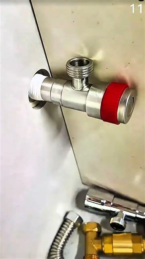 Installing red-handled valve onto wall-mounted plumbing fitting