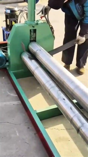 bending long silver metal strip using an automated industrial rotation machine #shorts