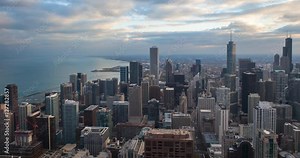 Chicago, Illinois, USA - view from the observatory of the John Hancock Center at illuminated City along Michigan Avenue with Tribune and Trump Tower at sunset - Timelapse with zoom in