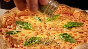 Download Adding Fresh Basil Leaves to Margherita Pizza in Napes, Italy for free