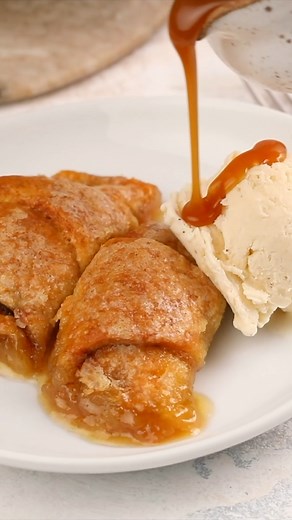These easy, yet decadent Peach Dumplings have all the best flavors and textures rolled up in one. You get warm and buttery, flaky and crispy, and sweet and spicy in every bite. Store-bought crescent rolls are filled with fresh peach slices and a brown sugar/cinnamon sauce, and then topped with a sweet butter glaze. #peachdumplings #peachrecipe Recipe from The Novice Chef https://www.dixiecrystals.com/recipes/peach-dumplings-with-brown-butter-caramel-sauce | Dixie Crystals