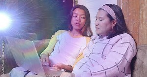 Mother pointing at laptop screen and teaching daughter tech tips in software tutorial