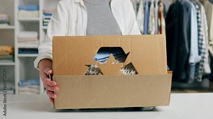 Recyclable materials, People sort and pack used clothes Caring person Selects and sorts used clothes Bright clothes Camera in motion Pretty woman Works actively in a clothes warehouse, wardrobe