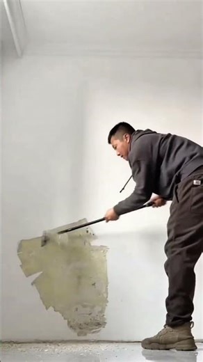 Efficiently Scraping Old Plaster and Paint from an Interior Wall Using a Long-Handled Scraper