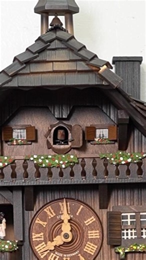 Traditional German Mechanical Bird Clock – 3 Weights This classic 3-weight mechanical bird clock reflects the traditional craftsmanship of Germany. Powered by a weight-driven movement, it features detailed wood carvings and lively figurines that portray scenes of rural life and domestic animals. The bellows system produces a natural bird call, warm and authentic in tone. Original, well-balanced in design, and rich in character, this vintage piece holds strong collectible value and makes a charmi