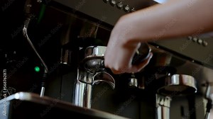 4K, Close-up hand holding coffee maker handle plugged into coffee maker, which coffee distiller comes out with warm water flowing through coffee water, before being used coffee drink in various menus.
