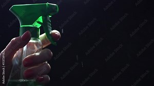 Beautiful female hand spraying window cleaner, slow motion