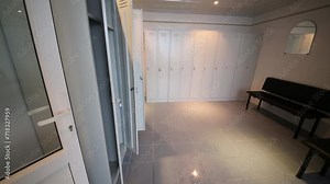 Light dressing room with rows of lockers and seats