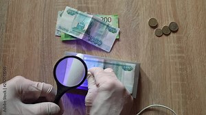 Verification of banknotes by an ultraviolet lamp for authenticity.