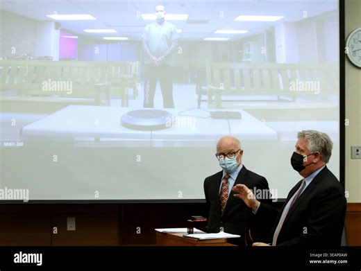 FILE - Defense attorney Mark Collins, right, speaks to the judge as defense attorney Steve Nodler, center, listens during the arraignment of former Franklin County, Ohio, deputy Jason Meade, appearing on video screen, Dec. 3, 2021, in Columbus, Ohio. (AP Photo/Paul Vernon, File Stock Photo - Alamy