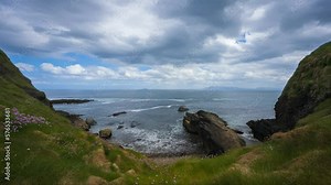 Timelapse of rugged coastline with moving clouds and grassland sea rocks in Aughris Head in county Sligo on the Wild Atlantic Way in Ireland.