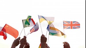 Different flags in human hands. People of different nationalities holding their countries flags outdoors. Concept of International communication.