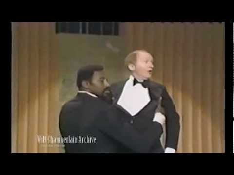 Wilt Chamberlain picks up a guy so effortlessly it looks like hes on strings