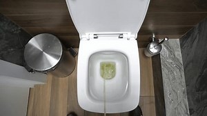 Des toilettes publiques modernes. Un homme pisse dans les toilettes. Une vue de dessus du processus d'émission d'un petit besoin dans la chambre des hommes.