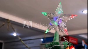 Christmas tree decoration with star top and colorful lights. Small decorated Christmas tree on a table in a room
