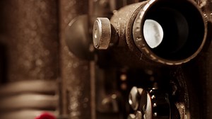 Download Extreme close up of 8mm movie projector showing a dusty and rusty lens projecting in 4K for free