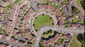 Drone fly-in view of new build residential flats arranged in a circular pattern, capturing the symmetry and modern design of the housing estate in Exeter, England