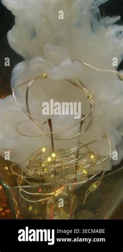 Vertical video. Vapor flow. Defocused garland illumination. White smoke color paint. Shimmering liquid splash golden light bulb abstract black background Stock Video Footage - Alamy