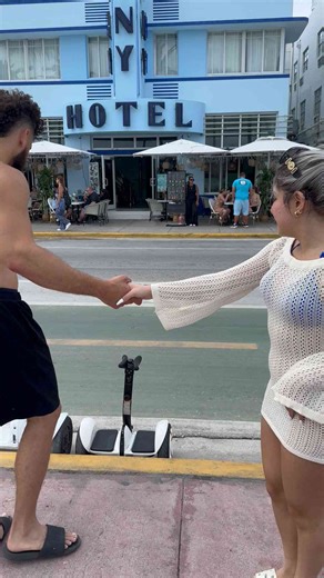 Guy lifts woman over head and rides his segway down the road with her!