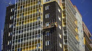 high-rise installation works, facade. high-rise buildings, skyscrapers. Builder wokring, rising on elevator. Construction of skyscrapers, construction site. Workers building modern high-rise building Stock Video