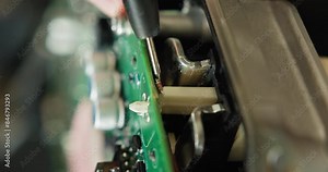 Detailed view of an electronic circuit board undergoing repair. Shows intricate components and precision work involved in electronics repair. EV repair concept. Auto Service, Electric vehicle engine
