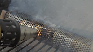 This video shows a heat gun setting a pellet smoker on fire as smoke pours over the grill. Stock Video