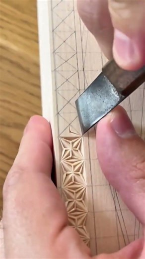 carving intricate geometric star patterns on a wooden surface using a sharp chisel with precision