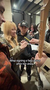 Wisp's Heartfelt Gesture: Signing a Fan's Guitar
