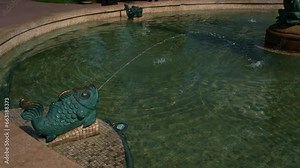 Fountain in city garden in form of frog with stream of water bursting out of its mouth