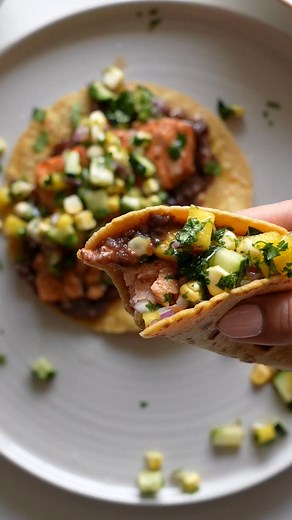 These salmon tacos are super easy and super delicious! Loaded with a mango, sweet corn, and cucumber salsa, they're the perfect summer pick-me-up! https://pyum.co/3J1X4ix | Pinch of Yum