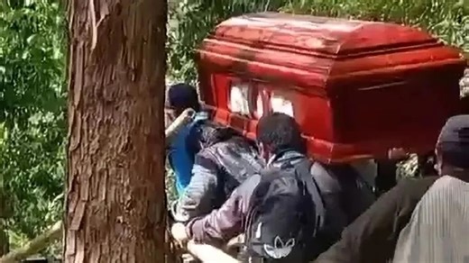 Moment coffin falls into stream & splits open as mourners scramble to save body