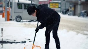 Japanese Man Shoveling Snow in During Winter in City of Sapporo, Hokkaido, Japan
