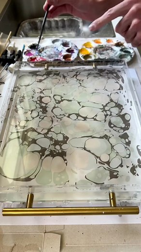 A stone pattern with earthy tones 🎨 . I used this marbled paper to make one of my fav notebooks recently. I loved how the colorful paints became muted on the dark paper. I’ll be making some new marbled patterns soon, so let me know if you have any requests, and stay tuned! #marbling #papercraft #bookarts #paperlovers #relaxingart #satisfyingartvideos #pnwartist