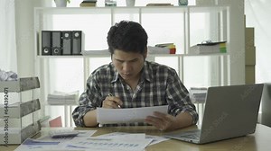 Asian young man excited about successful business Young businessman using computer in office He was energetic and excited about what he was watching on his laptop.