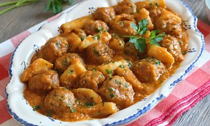 Sepia con albóndigas. Un clásico de mar y montaña. Ingredientes Para 4 a 6 personas Para las albóndigas: 400 g de carne picada mixta (cerdo y ternera) 1 huevo 50 ml de leche 50 g de pan rallado Ajo y perejil picados Harina para rebozar Para el guiso: 1 sepia grande (600 g) 1 cebolla 2 dientes de ajo Ajo y perejil picados 150 g de salsa de tomate 1 vaso de vino blanco Sal, pimienta, aceite de oliva 500 ml de agua Para la picada (majado): 3 reabanaditas de pan 1 diente de ajo 15 almendras tostadas