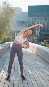 Caucasian athletic woman runner stretching body warm up before workout preparing for outdoor jog girl wearing sportswear raising arms morning exercises outside in park. Health wellbeing energy life