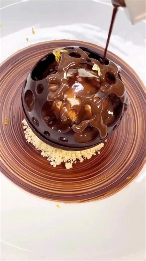 Grand Cru chocolate, citrus notes, and molten elegance in every layer 🍫🍊 A hand-crafted sphere by @stefthepastrychef melts open to reveal vanilla ice cream, silky ganache, dulce de leche, and blonde chocolate pearls—all on a buttery shortbread base. Finished with gold leaf for a touch of luxury ✨ • • • Want to be featured on @pastryartsmag profile? Tap our bio link for info.☝ | Pastry Arts: Magazine, Podcast, Summit, Shop & Community