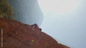 vertical shot. climber boy. the child trains in rock climbing. sports in nature. boy goes in for sports. rock climbing for children. safety in sports.