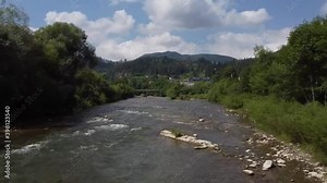 Mountain river in the mountains in summer. Green trees and sky. Verkhovyna, Drone Video. Hutsul region of the Carpathian Mountains. Cheremosh River. Ukraine.
