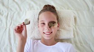 Beautiful girl with tea bags on eyes. Top view.