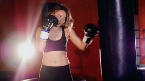 A heavy bag boxing exercise by a young woman.