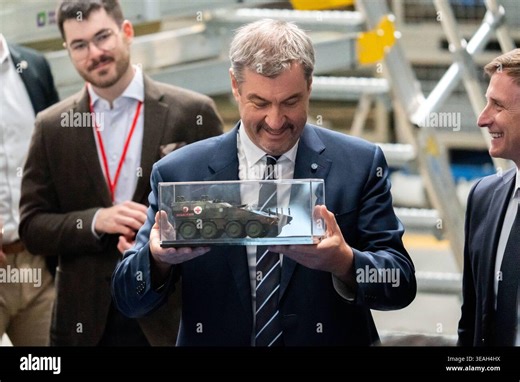 Munich, Bavaria, Germany April 22, 2026: Inauguration of the new production line for the 8x8 BOXER wheeled vehicle at KNDS in Munich to increase delivery capacity for the German Armed Forces and allied nations. Dr. Markus Söder Minister-President of Bavaria, CSU holds a miniature tank in his hand *** Eröffnung der neuen Produktionsstraße für das 8x8-Radfahrzeug BOXER bei KNDS in München zur Steigerung der Lieferkapazitäten für die Bundeswehr und Alliierte. Dr. Markus Söder Ministerpräsident Baye