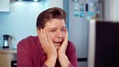 Man crying working at the computer