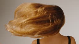 Portrait of a beautiful woman showing off and tossing beautiful long...