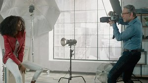 Behind the Scenes on Photo Shoot: Beautiful Black Model Posing for a Photographer, He Takes Photos with Professional Camera. Stylish Fashion Magazine Photoshoot done with Pro Equipment in a Studio