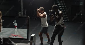 actor wearing motion capture suit rehearsing martial arts with instructor teaching fighting moves mo-cap suit for 3d character animation for virtual reality technology