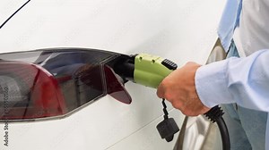 A man cannot insert a charging cable into an electric car