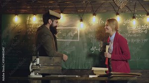 Professor and secretary working on blackboard chalkboard. Portrait of professor teaching mathematics to students. Young woman solving math problem while writing on blackboard. Tutor teacher concept.