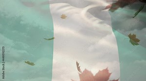 Digital composition of nigeria waving flag over autumn leaves falling against clouds in the sky